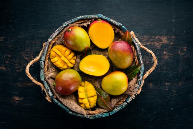 Mango fresco in una scatola di legno Su uno sfondo di legno Frutti tropicali Vista dall'alto Spazio libero per la copia