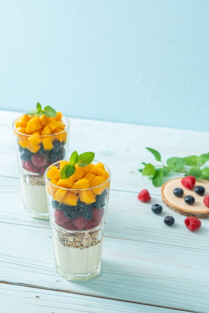 mango, lampone e mirtillo fatti in casa con yogurt e muesli. stile alimentare sano