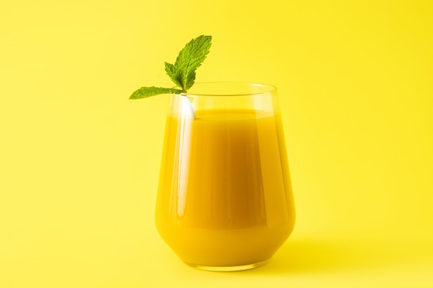 Mango Lassi dessert tradizionale bevanda indiana su sfondo giallo