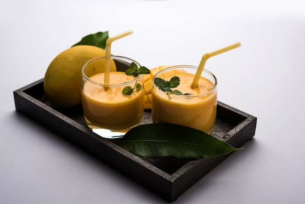 Mango Lassi o yogurt, bevanda estiva popolare indiana servita in vetro con tutta la frutta Alphonso Aam, messa a fuoco selettiva