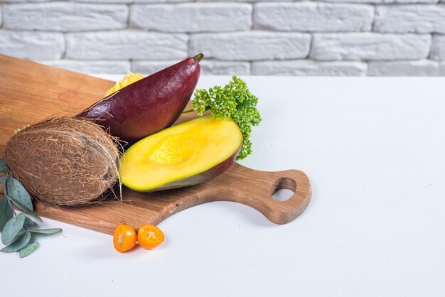 Mango tritato su due metà con frutti su bianco