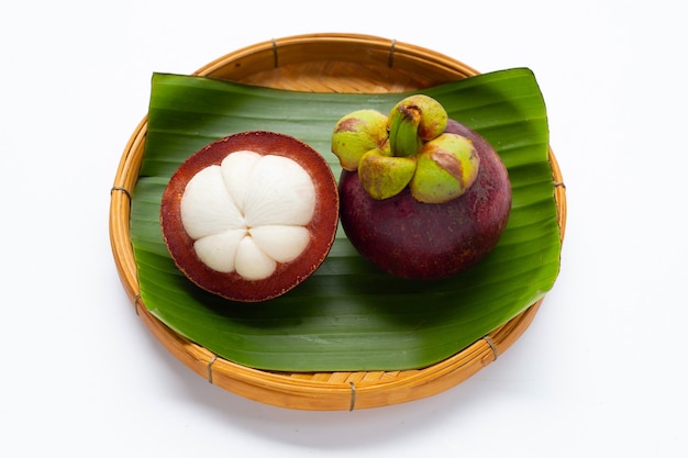 Mangostano in cesto di bambù su sfondo bianco.