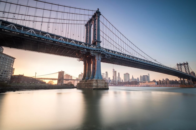 Manhattan Bridge visto dalla costa accanto all'area DUMBO durante il tramonto con cieli completamente sereni