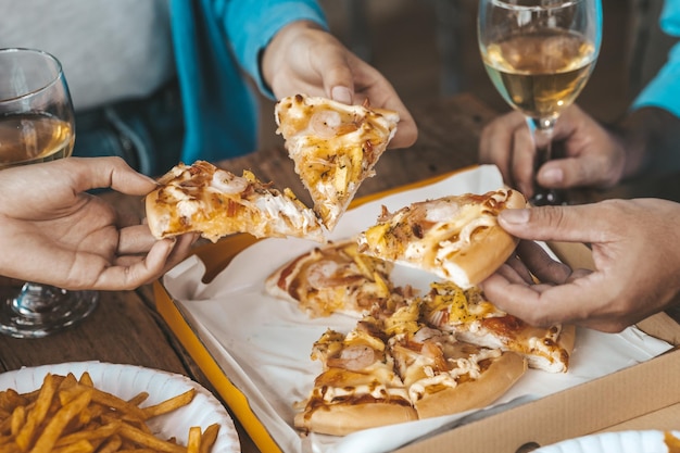 Mani alle persone che raccolgono la pizza su un vassoio per mangiare startup feste aziendali feste di capodanno riunioni annuali aziendali bevande alcoliche festa dei dipendenti dell'azienda idee per il catering celebrazioni della pizza