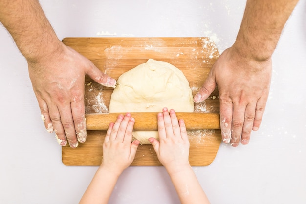 Mani arrotolate di papà e bambini.