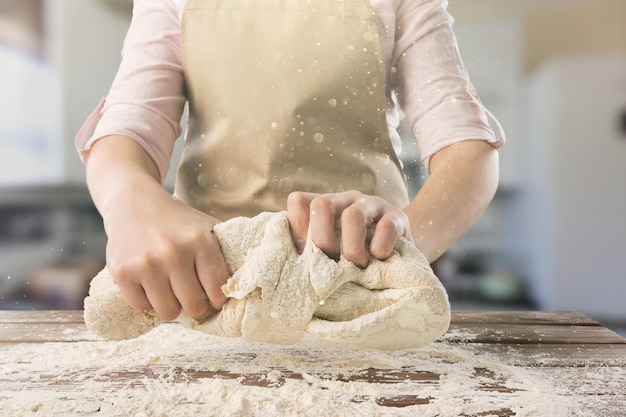 Mani belle e forti impastano la pasta per fare il pane, la pasta o la pizza.