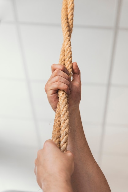 Mani che afferrano le corde in palestra