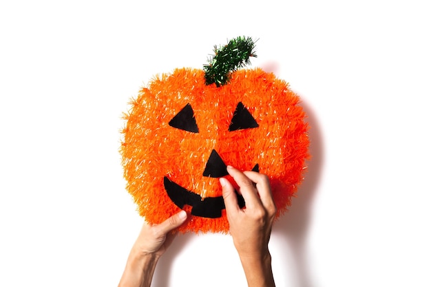 Mani che fanno un mestiere di zucca di Halloween fatto in casa