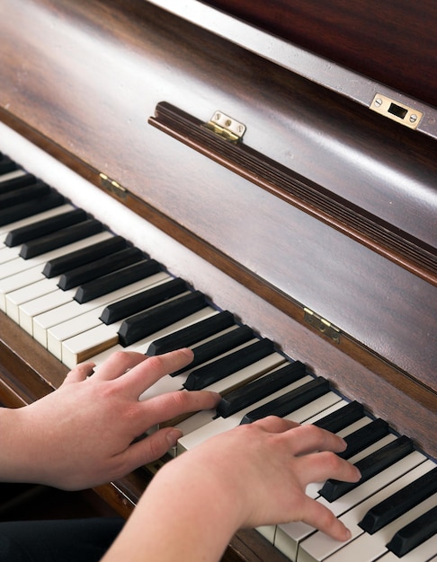 Mani che imparano a suonare il piano a casa in un'atmosfera tranquilla Persona che compone musica classica rilassante usando una tastiera musicale Un pianista che migliora e si esercita per padroneggiare lo strumento classico