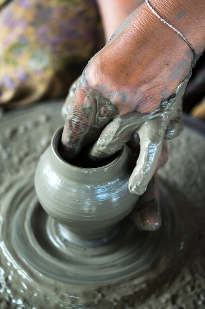 Mani che lavorano alla ruota di ceramica