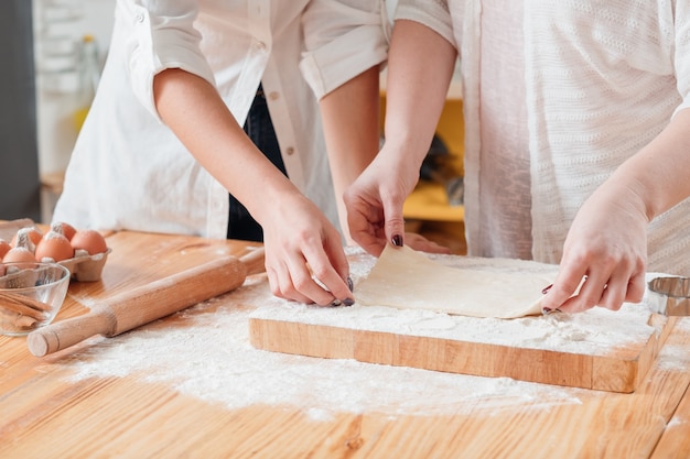 Mani che lavorano con la pasta che prepara i biscotti