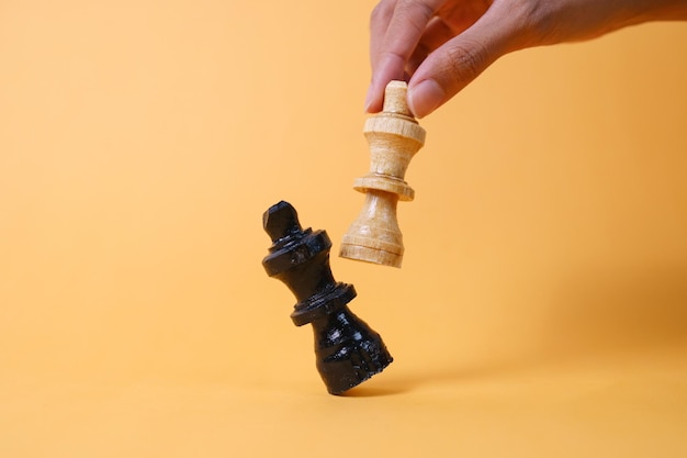 Mani che muovono una figura di scacchi in un gioco di successo di competizione Gestione strategica o concetto di leadership