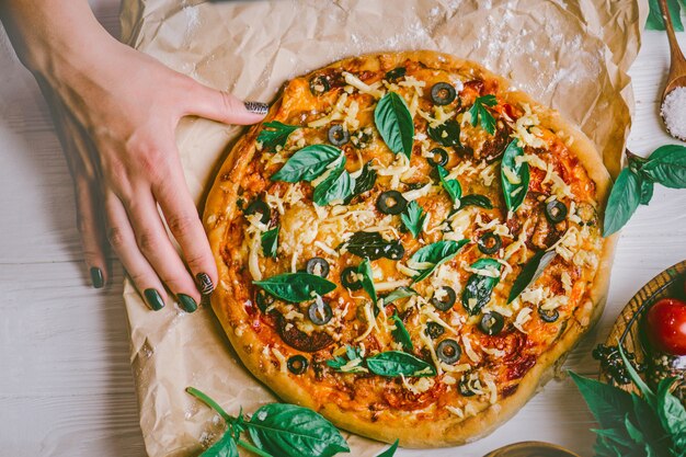 Mani che prendono fette di pizza. Mano che tiene la pizza fetta.