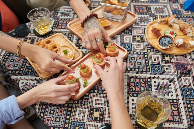 Mani che prendono spuntini dal piatto