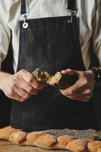 Mani che rompono e separano le baguette organiche fresche