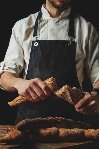 Mani che rompono e separano le baguette organiche fresche