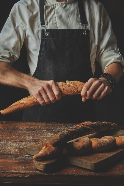 Mani che rompono e separano le baguette organiche fresche