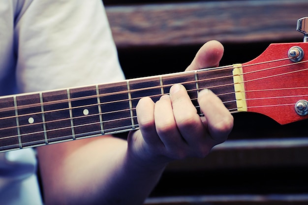 Mani che suonano la chitarra acustica, primi piani