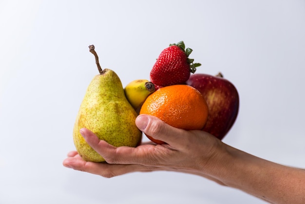 Mani che tengono frutta e verdura