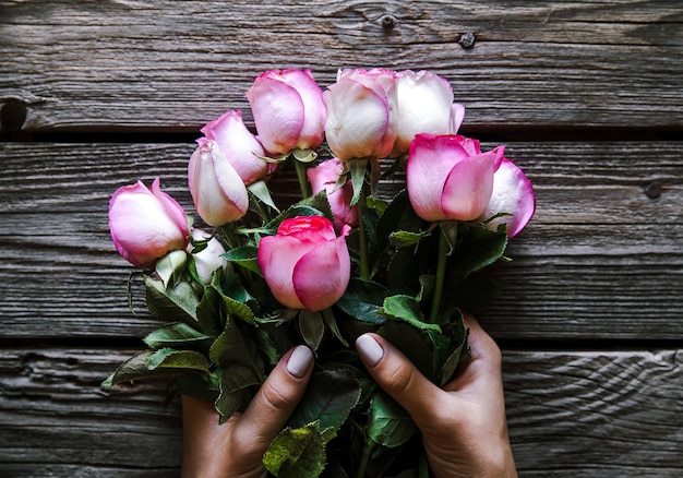 Mani che tengono il mazzo di belle rose rosa. fiori