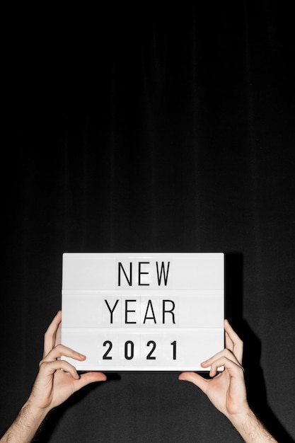 Mani che tengono il segno del nuovo anno 2021 con lo spazio della copia