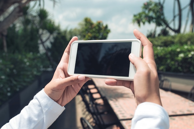 Mani che tengono il telefono con lo schermo vuoto