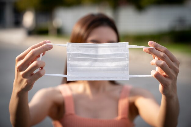 Mani che tengono la maschera protettiva medica.