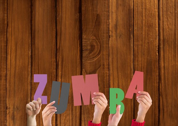 Mani che tengono la parola Zumba su sfondo di legno