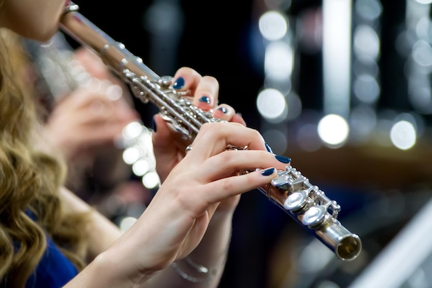 Mani che tengono un flauto Ragazza musicista suona il flauto