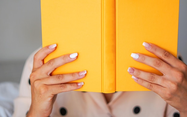 Mani che tengono un libro Mettendo a fuoco un libro giallo