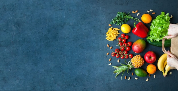 Mani che tengono un sacchetto di carta con cibo vegetariano sano Varietà di frutta e verdura