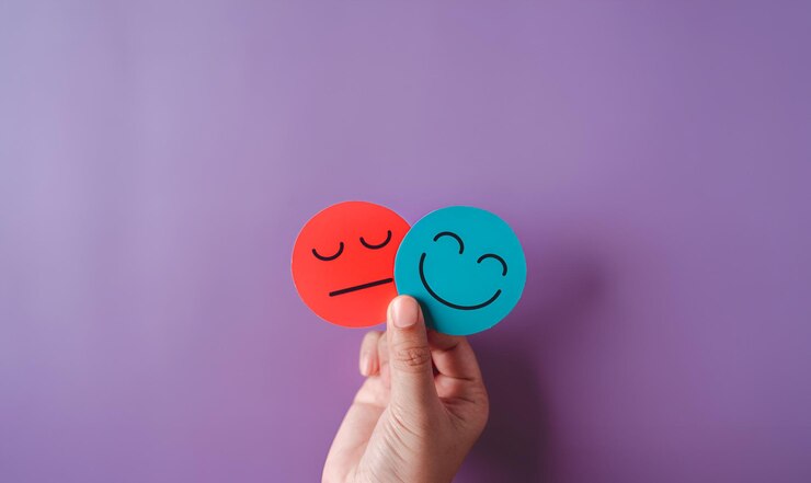 Mani che tengono una faccia triste nascosta o dietro una faccia sorridente felice bipolaria e depressione concetto di salute mentale personalità terapia di cambiamento di umore guarigione concetto di divisione su sfondo viola