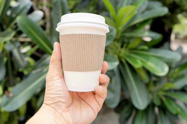 Mani che tengono una tazza di caffè che può essere riciclata Il caffè è una delle bevande più popolari