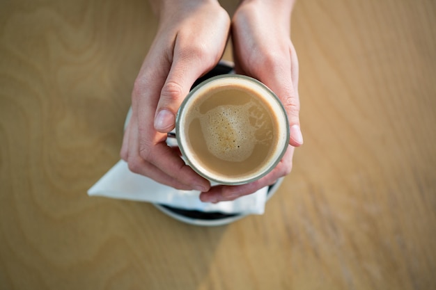 Mani che tengono una tazza di caffè