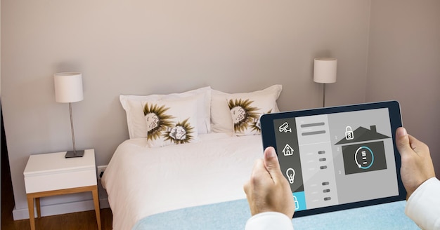 Mani che utilizzano l'app casa intelligente su tablet PC in camera da letto