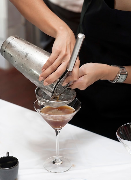 Mani che versano cocktail