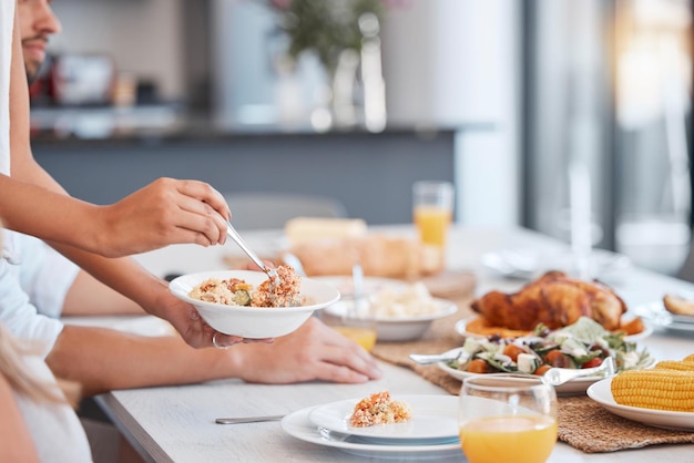 Mani cibo e cena sul tavolo per la preparazione del pranzo pasto o ringraziamento dando tempo a casa Piatto a mano insalata sana sul piatto da mangiare in una cucina raffinata famiglia affamata o ringraziamento nella sala da pranzo