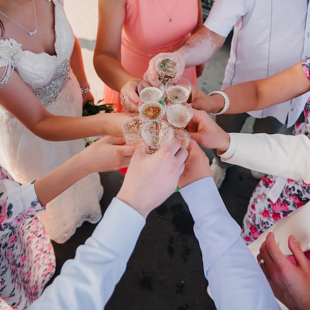 Mani con bicchieri di champagne amici al matrimonio