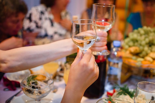 Mani con bicchieri di vino tintinnio di bicchieri a una celebrazione