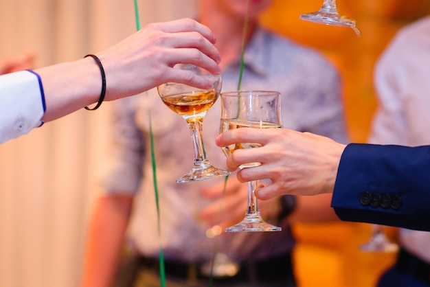 Mani con bicchieri di vino tintinnio di bicchieri a una celebrazione