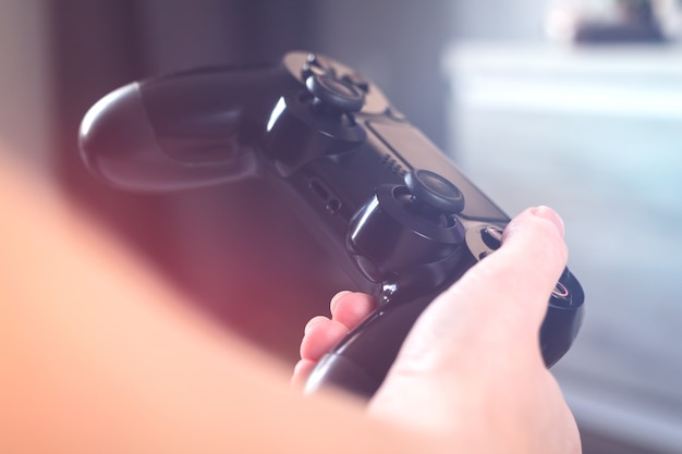 Mani con controller joystick, concetto di streaming online, gioco e sfida di eSport. Vista ravvicinata del gamepad