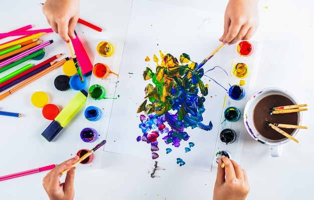 Mani con pennello pittura con acquerello macchie astratte mani di bambino pittura