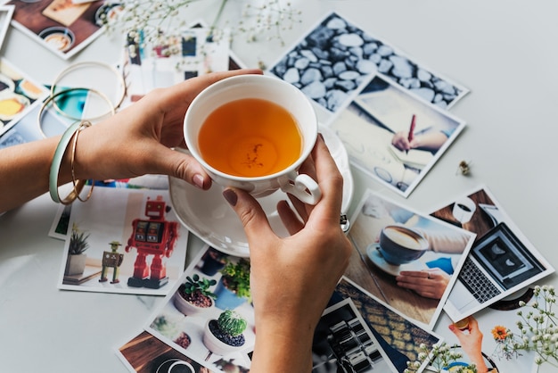 Mani con una tazza di tè e fotografia