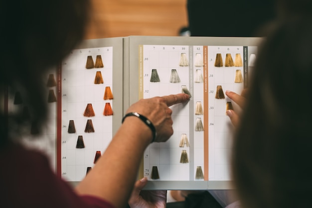 Mani da donna con un catalogo di coloranti