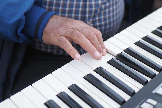 Mani degli uomini che suonano il pianoforte a coda