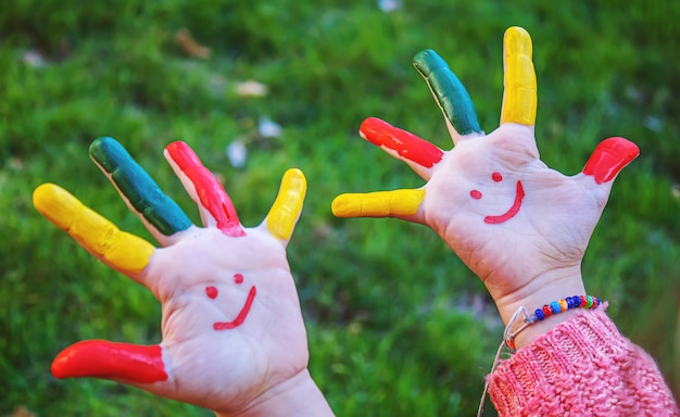 Mani dei bambini a colori. Foto d'estate. Messa a fuoco selettiva.