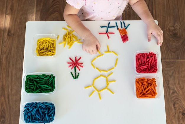 Mani dei bambini che giocano con la pasta colorata per giochi sensoriali e attività artigianali Imparare i colori attività per i bambini Giochi Montessori per la motricità fine giochi per i più piccoli