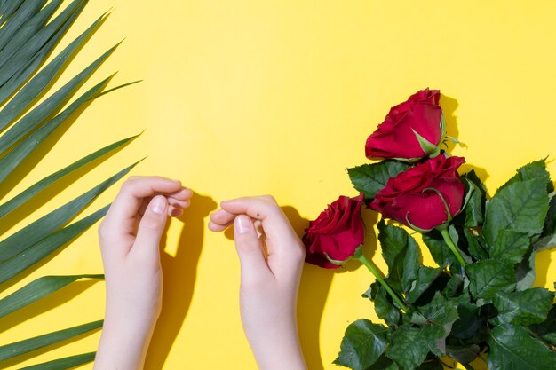 Mani dei bambini e foglie rosa della felce di rose, concetto di festa della mamma