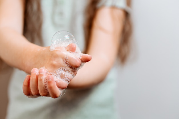 Mani dei bambini in schiuma saponata.