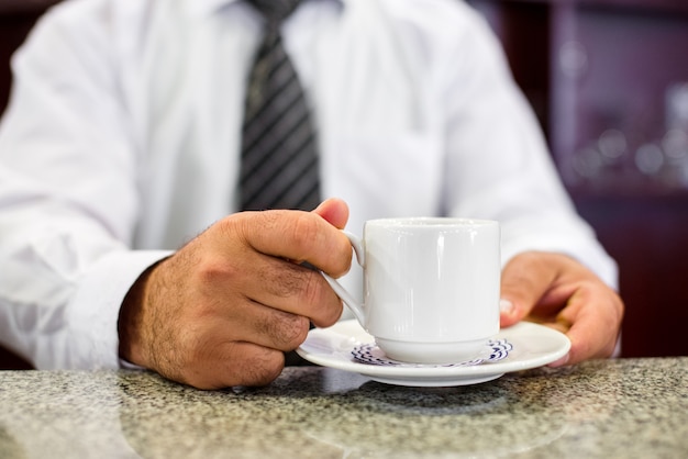 Mani del barista che tengono tazza di caffè